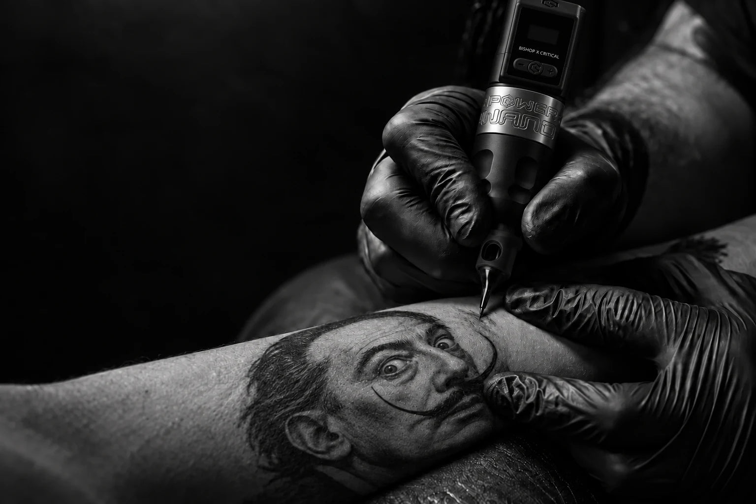 Il gesto preciso di un tatuatore al lavoro